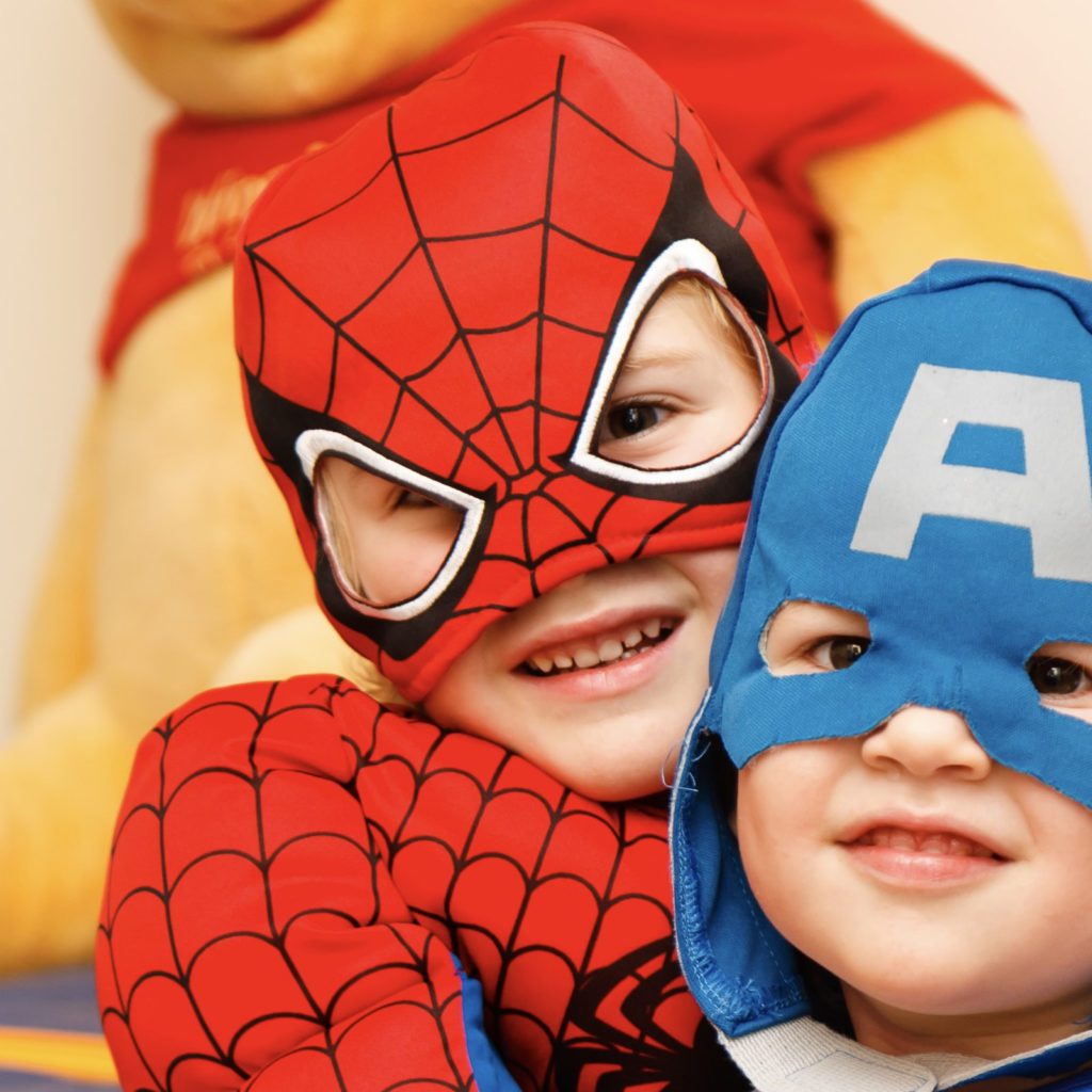 2 boys dressed in super hero costumes | how to set up a budget for your kids | teaching kids about money | Positively Jane  