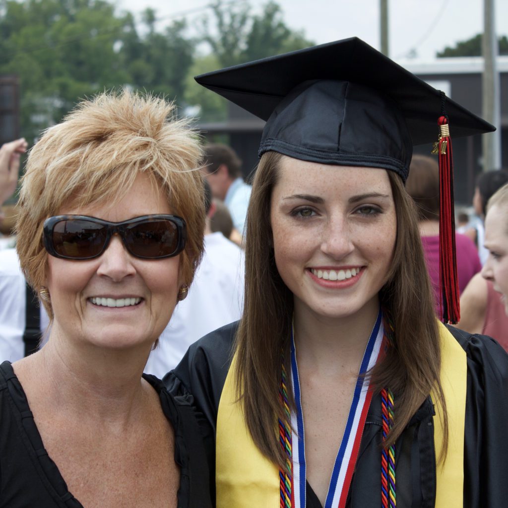 mom standing next to her daughter who has a cap and gown on for graduation | is going to college the right choice | Positively Jane