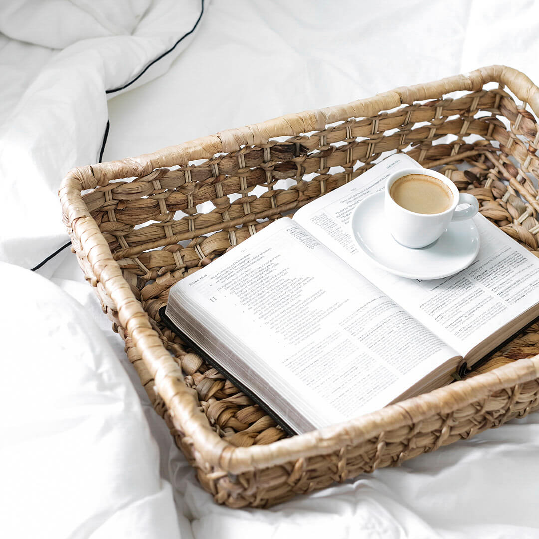 open bible with a cup of coffee on a wicker tray