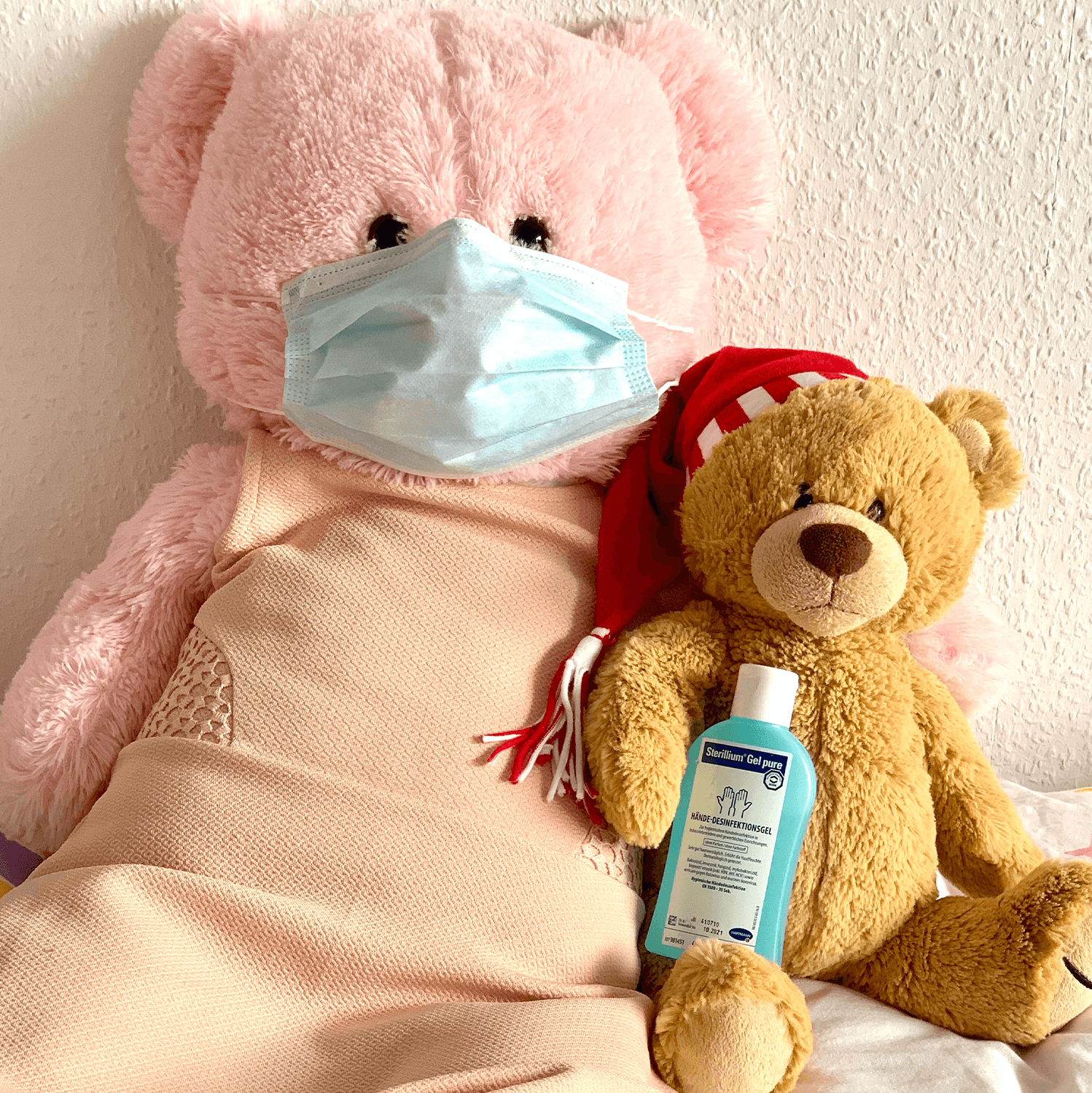 2 teddy bears in bed wearing face masks