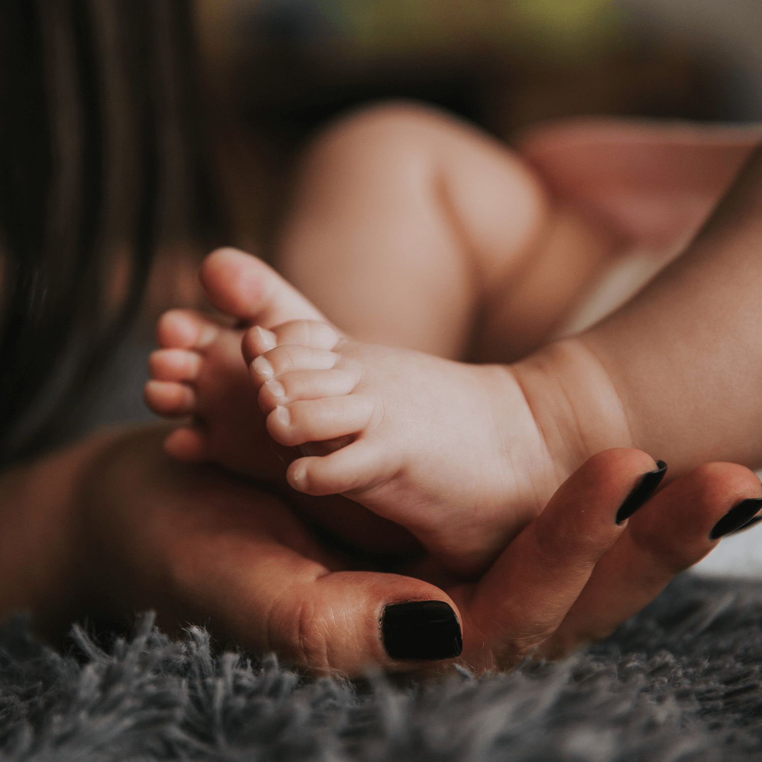 woman holding babies foot