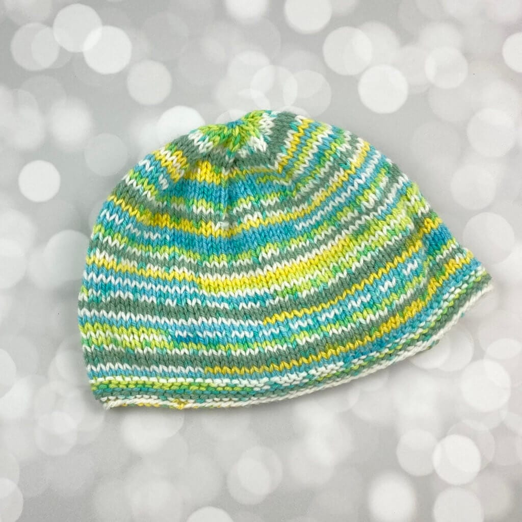 hand knit baby cap in greens and yellows