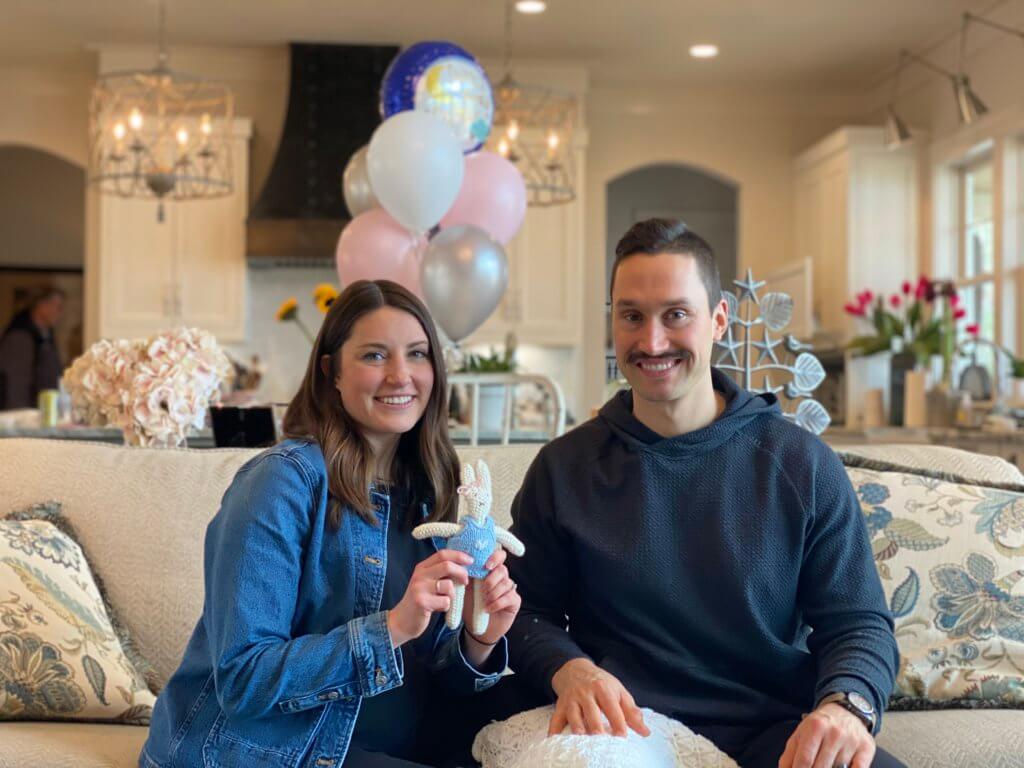 Nicole and Zach holding a cute little knitted bunny | hosting a virtual baby shower | Positively Jane 