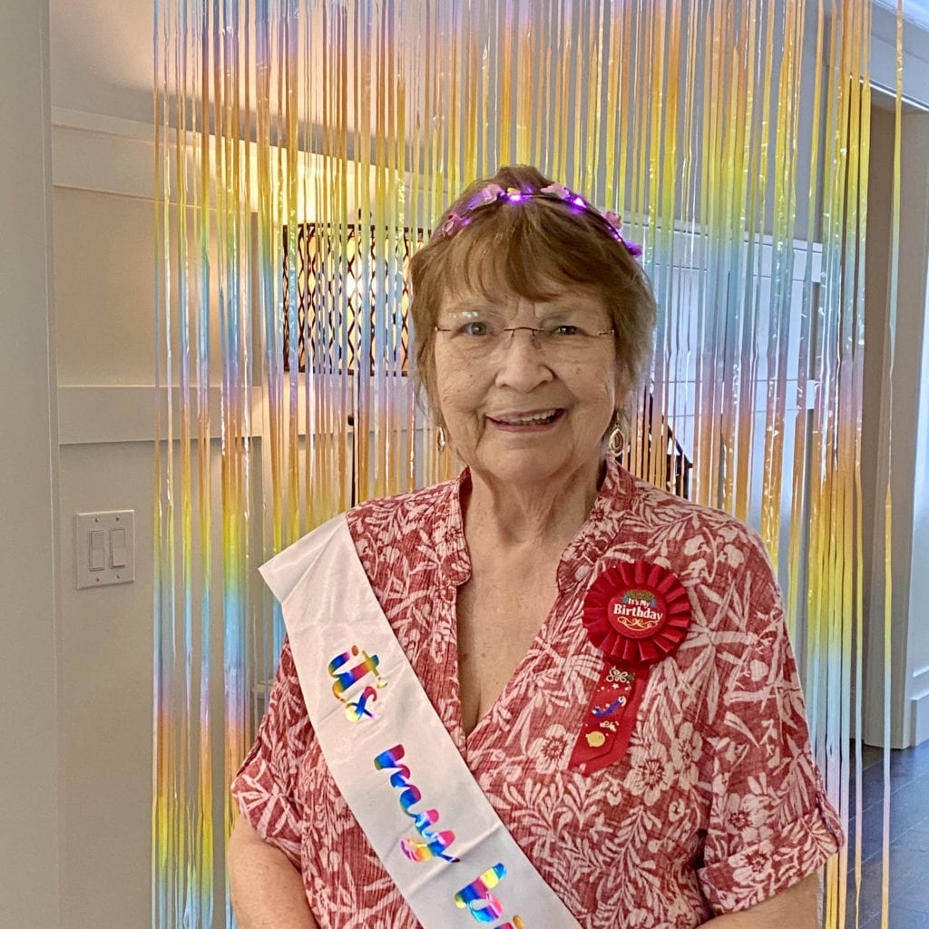 older woman wearing a crown and banner to celebrate her birthday