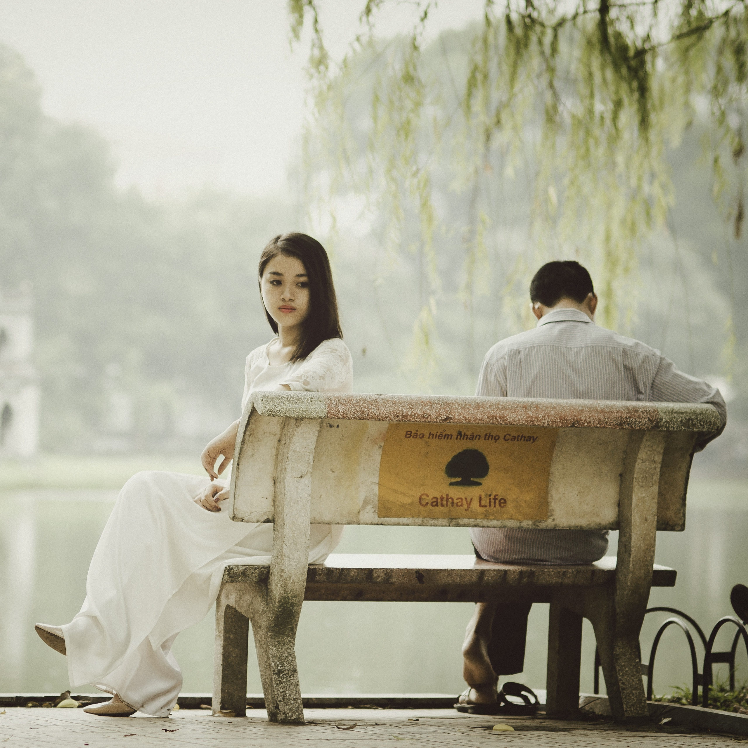 man and woman sitting on a bench arguing