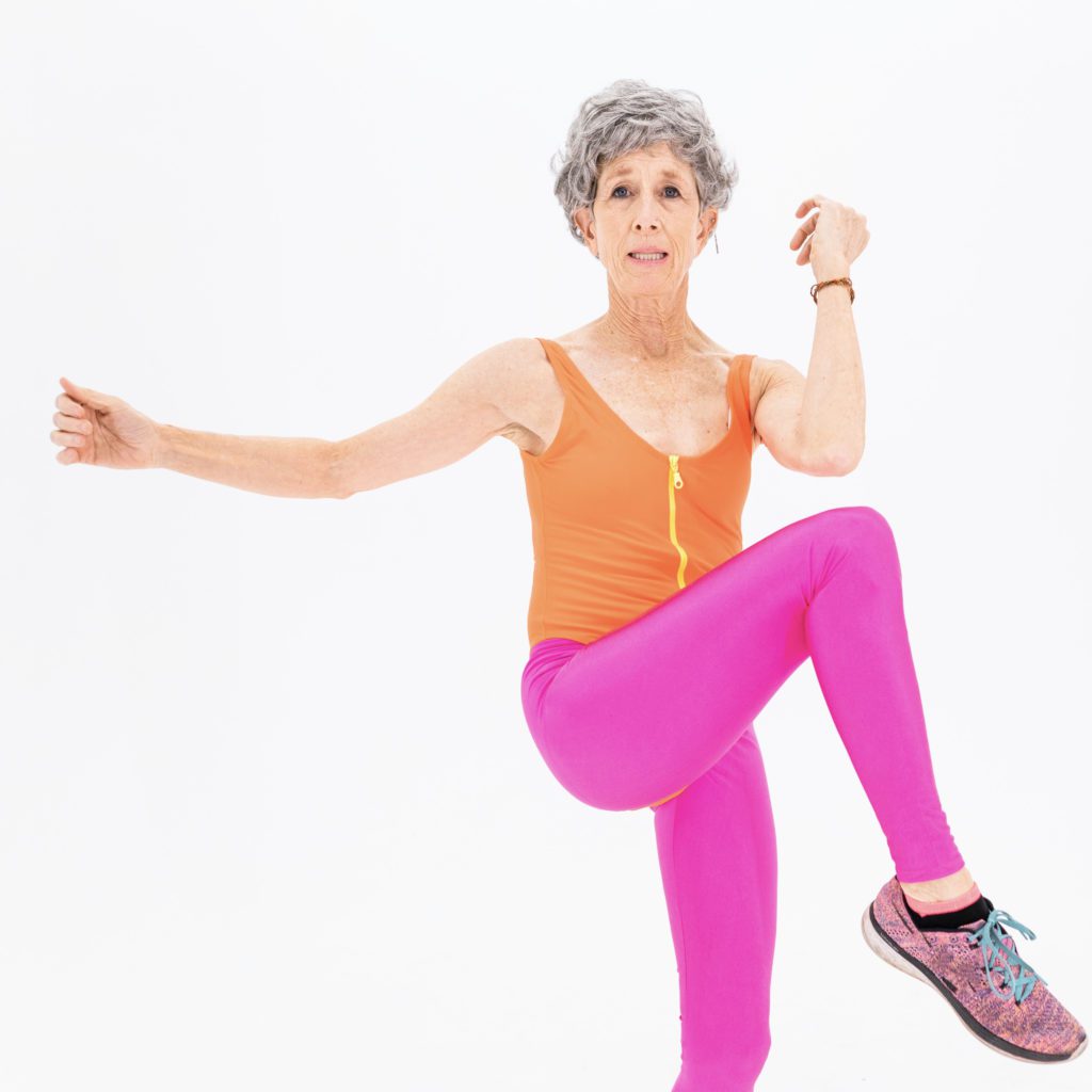 woman dressed in pink and orange standing on one leg | living a balanced life | Positively Jane