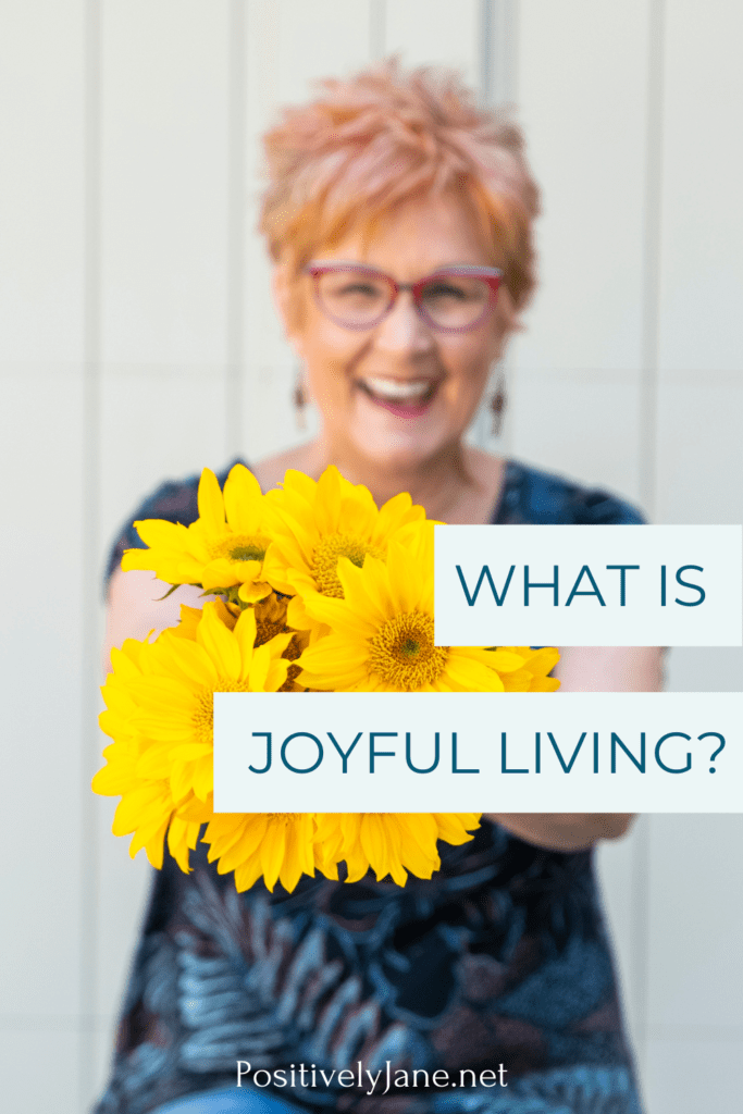 girl holding flowers with the words what is joyful living pin for Pinterest | Joyful living | Positively Jane 