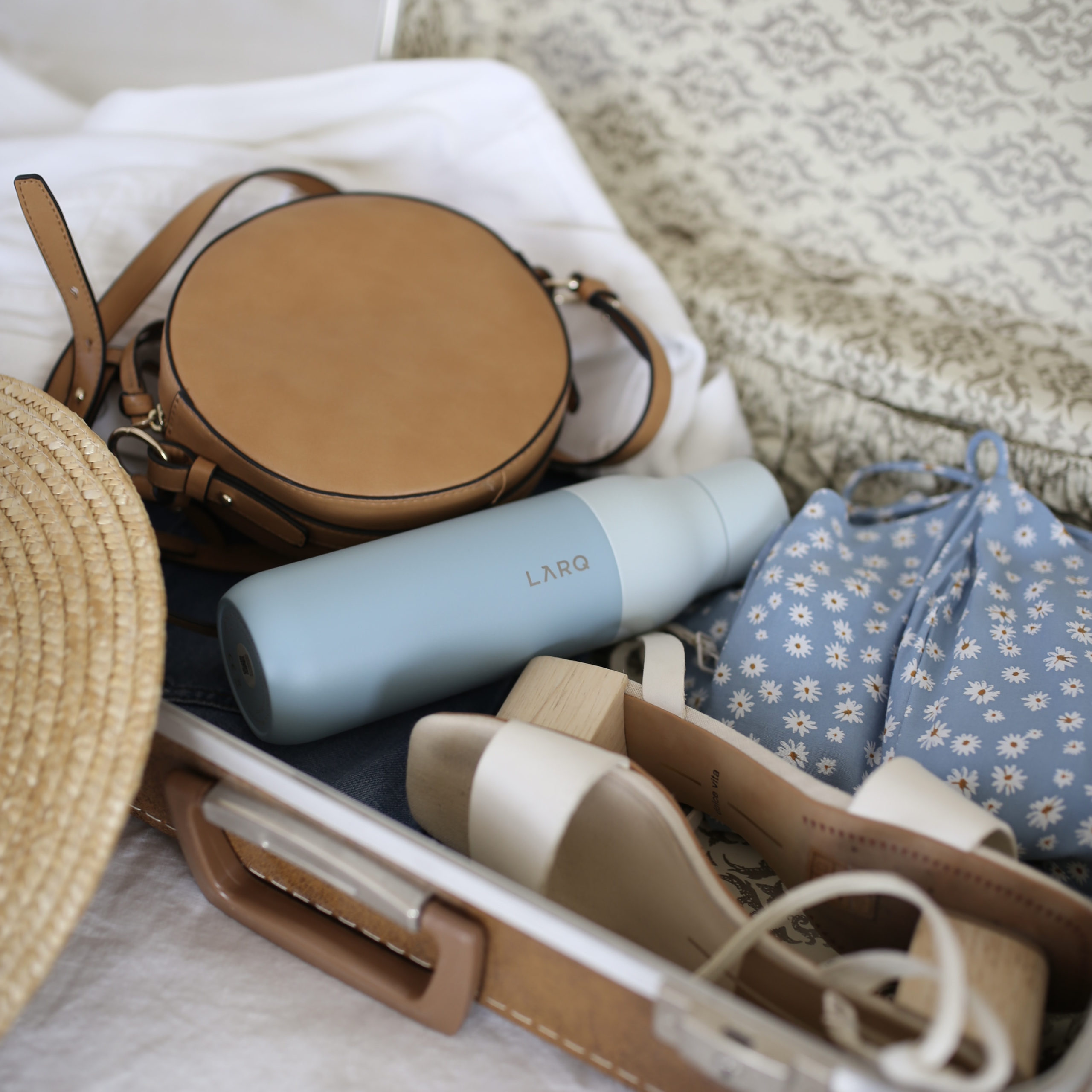suitcase on the floor with a few items packed inside of it | vacation packing list | Positively Jane