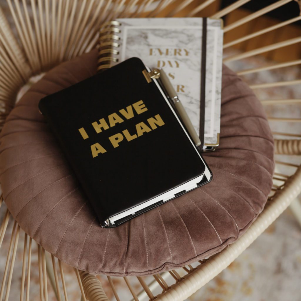 I have a plan written on a black notebook. the notebook is sitting on a chair | Bite size your to-do list | 7 things you can do | Positively Jane