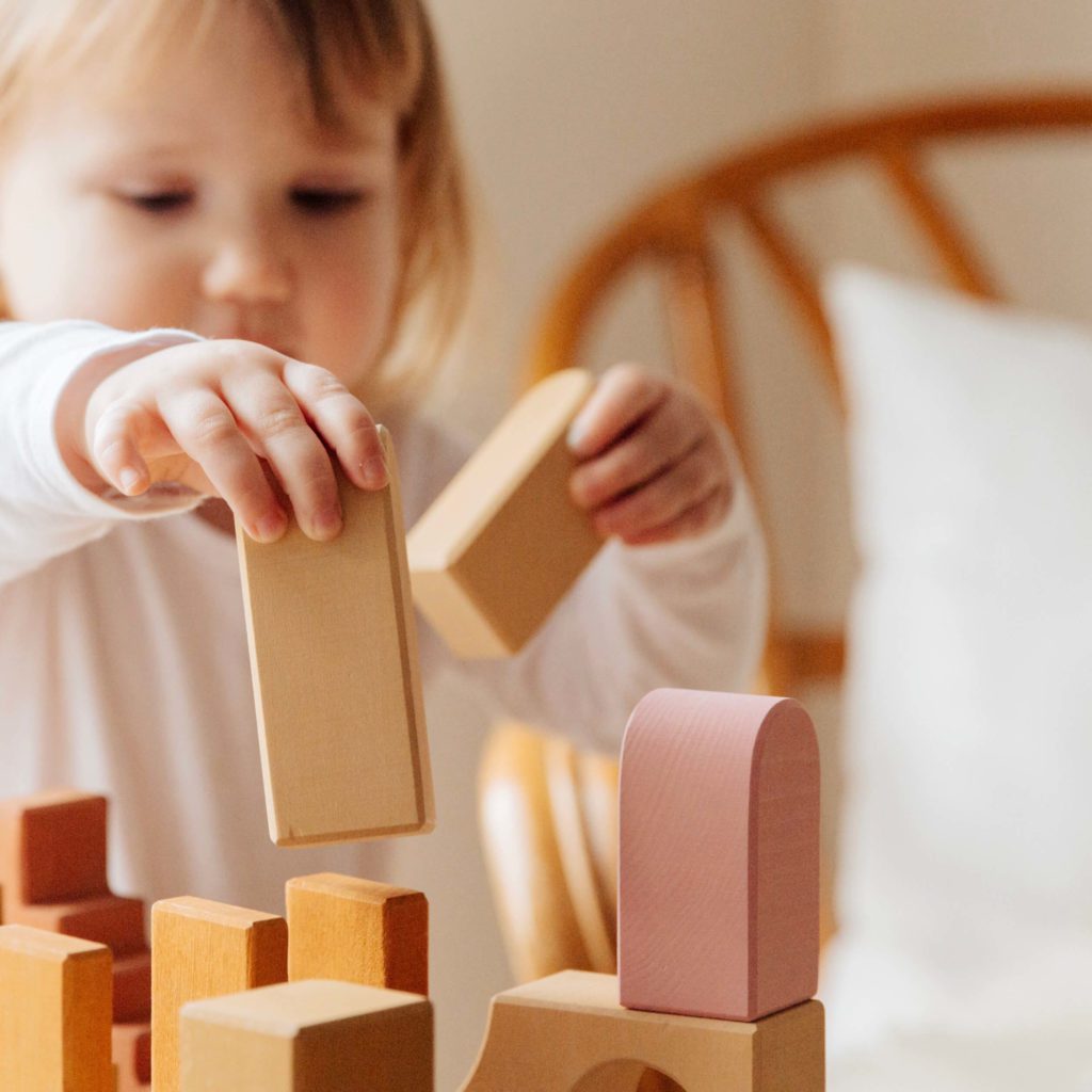 little girl stacking blocks | fun family games | Positively Jane