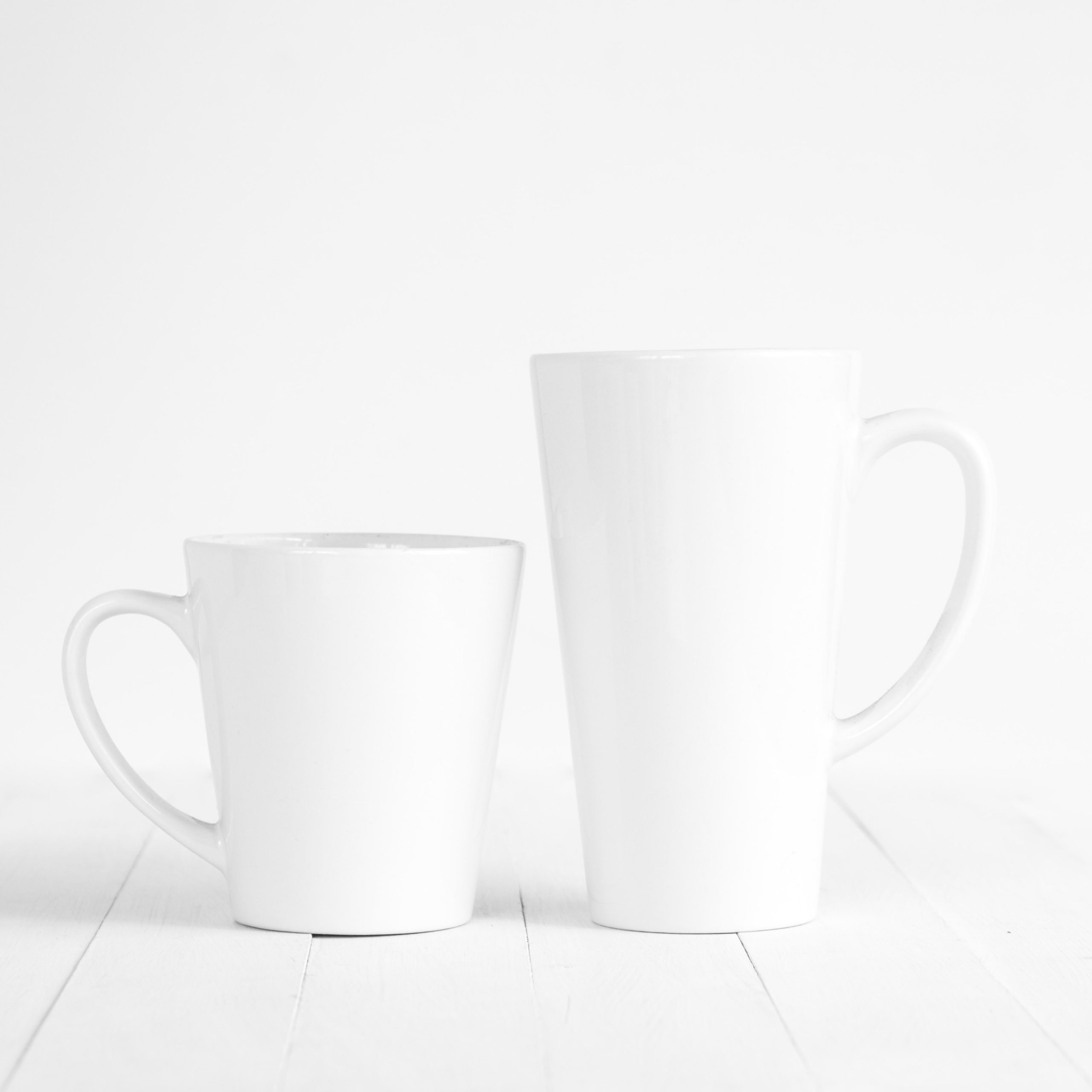 2 white coffee mugs sitting side by side. One is taller than the other | The comparison trap | Comparison is the thief of joy | Positively Jane