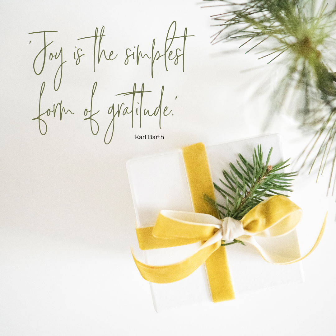 package wrapped in white paper with a yellow velvet ribbon and a spring of greenery in the package and laying on the side | finding joy in the holidays | Positively Jane