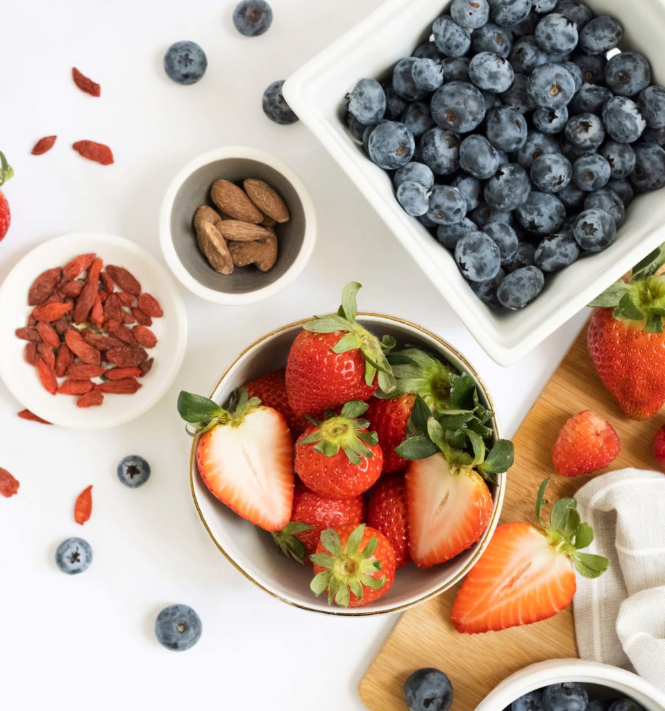 strawberries, blueberries, and almonds in white dishes and on the white counter | 15 healthy daily habits | Positively Jane