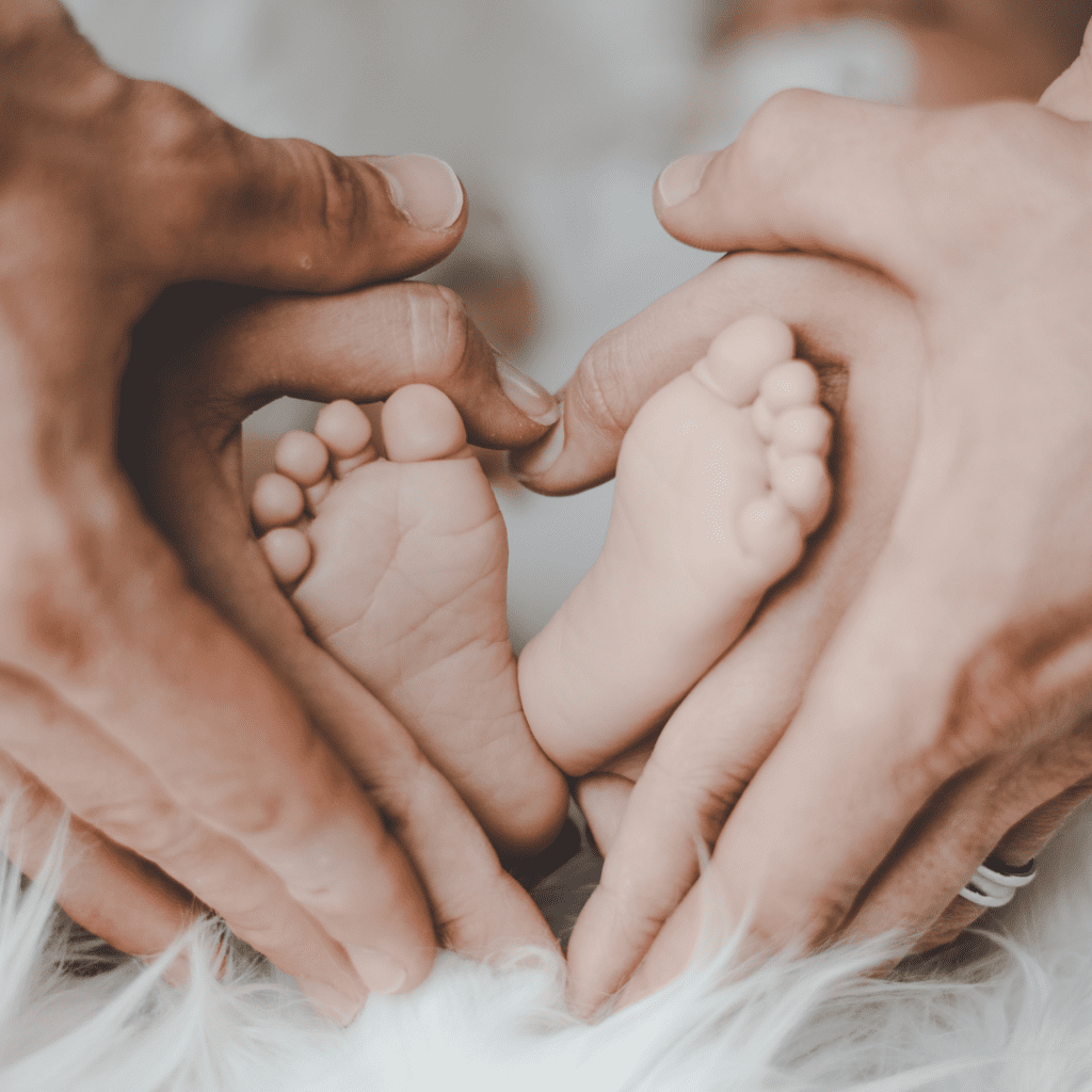 2 pair of hands surrounding a baby's foot | how to be rich | Positively Jane