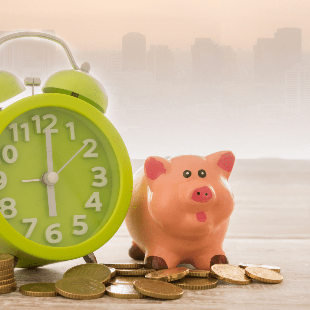 green clock sitting next to a pink piggy bank with coins on the table | what is the fire movement | positively jane